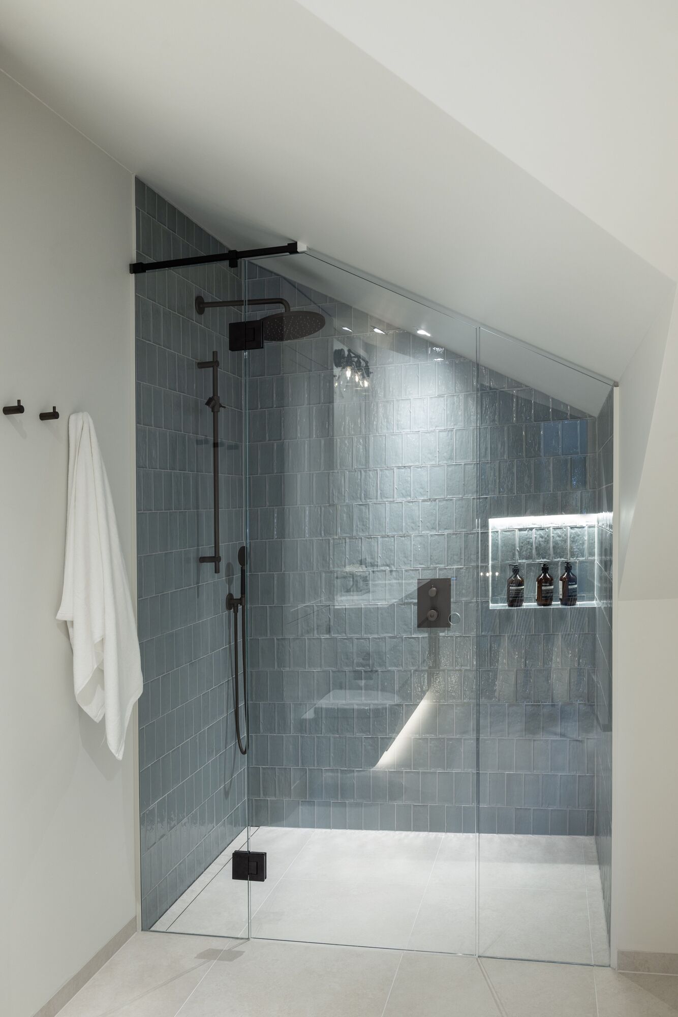 Shower lined in blue-green glazed tile