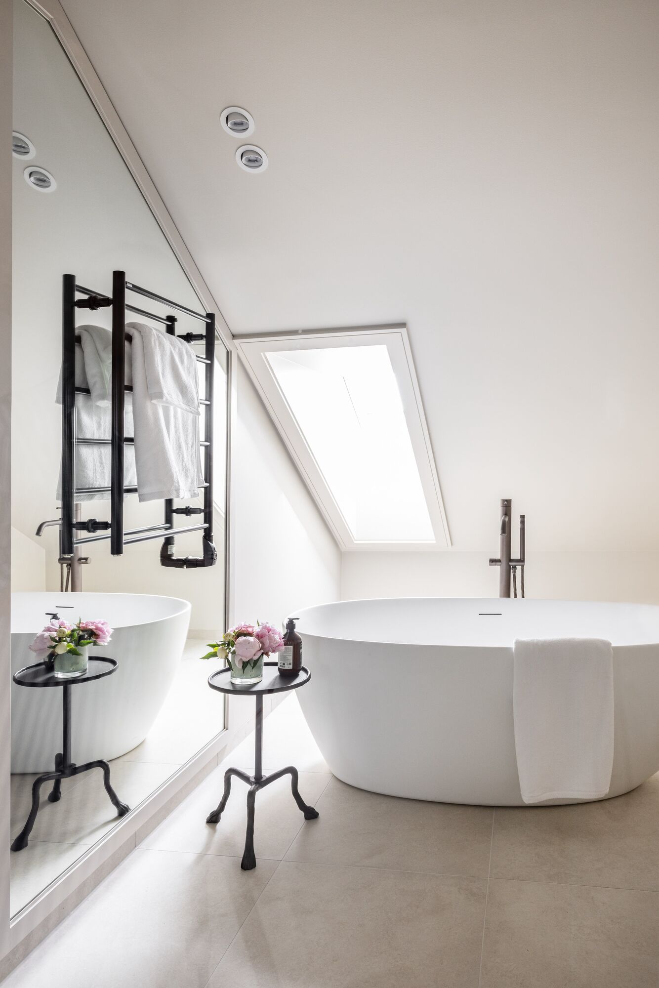 A freestanding bath beneath a skylight