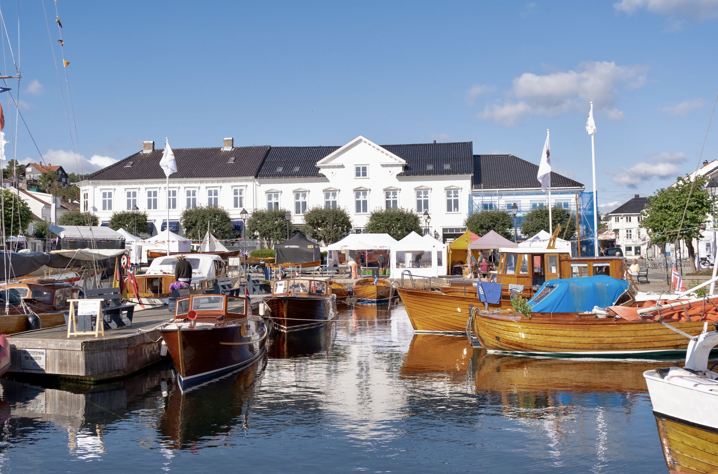 Torvet 4 at the centre of the harbour front in Risør, wooden boats moored at the quay