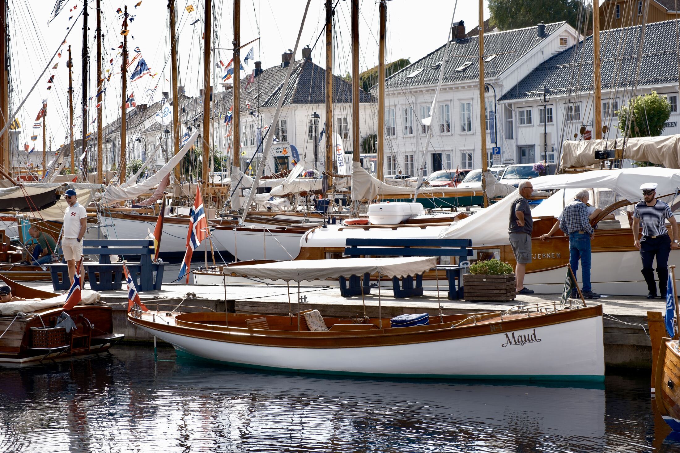 People on the quay among the wooden boats during the festival